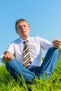 Happy businessman relaxes in a field