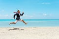 Happy businessman running away from office work on the beach. Summer vacation concept Royalty Free Stock Photo