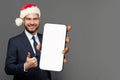 Happy businessman Santa holding smartphone with blank empty screen display