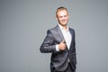 Happy businessman showing his thumb up with smile on gray Royalty Free Stock Photo