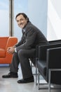 Happy Businessman Sitting In Office Lobby Royalty Free Stock Photo