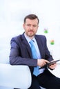 Happy businessman sitting on the sofa looking at camera in the office Royalty Free Stock Photo