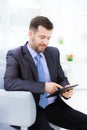 Happy businessman sitting on the sofa looking at camera in the office Royalty Free Stock Photo