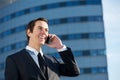 Happy businessman smiling and talking on mobile phone outdoors Royalty Free Stock Photo