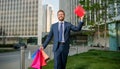 happy businessman in suit hold packages and gift box walking outside the office, greeting. Royalty Free Stock Photo