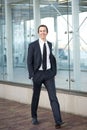 Happy businessman in suit walking on sidewalk in the city Royalty Free Stock Photo