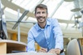 Happy businessman taking notes while working in modern office, standing by his desk, using a modern computer and writing something Royalty Free Stock Photo