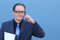 Happy businessman talking on the phone with folder in hand over blue background in studio shooting Royalty Free Stock Photo