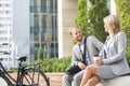 Happy businessman talking to female colleague in city