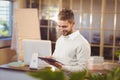 Office professional man standing at desk in modern office holding tablet with flip chart and plants Royalty Free Stock Photo