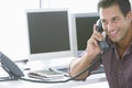 Happy Businessman Using Landline Phone In Office