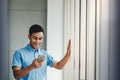 Happy Businessman Using Smartphone.Standing by the Window in Office