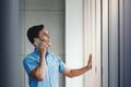 Happy Businessman Using Smartphone and Standing by the Window in Office. Talking with someone via Mobile Phone Royalty Free Stock Photo