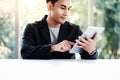 Happy Businessman Working on Digital Tablet in Office. Sitting at the Desk and Smiling Royalty Free Stock Photo