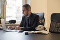 happy businessman working on laptop in office sitting next to dog with a tie Royalty Free Stock Photo