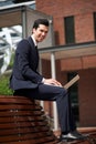 Happy businessman working on laptop outside the office Royalty Free Stock Photo