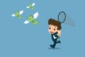 Happy businessmen use insect trapping nets to trying, running to catch a swarm of banknotes with wings who flying in the air. Royalty Free Stock Photo