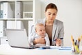 Happy businesswoman with baby and laptop at office
