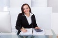 Happy businesswoman calculating tax Royalty Free Stock Photo