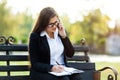 Happy businesswoman calling on mobile phone and taking notes outdoor Royalty Free Stock Photo
