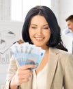 Happy businesswoman with cash money in office