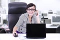 Happy businesswoman chatting on phone at office Royalty Free Stock Photo