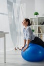 Businesswoman exercising on fitness balls in office