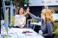 Shot of two female coworkers high-fiving each other after a well done job