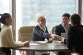 Happy businesswoman handshaking businessman over conference table at team meeting Royalty Free Stock Photo