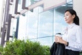 Businesswoman holding coffee outside office building. beautiful Royalty Free Stock Photo