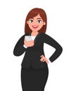 Happy businesswoman holding smartphone and posing hand on hip. Mobile phone, technology, mobile apps concept. Royalty Free Stock Photo