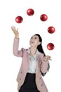 Happy businesswoman juggling with red balls