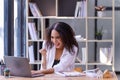 Happy businesswoman laughing with joy at the good news about work at the workplace, gladly looking at laptop screen, feeling