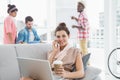 Happy businesswoman phoning and using laptop on couch Royalty Free Stock Photo