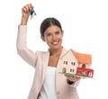 Happy businesswoman holding keys and presenting house model Royalty Free Stock Photo