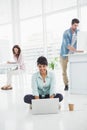 Happy businesswoman sitting on the floor using laptop Royalty Free Stock Photo