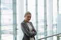 Happy Businesswoman standing with arms crossed in the corridor at office Royalty Free Stock Photo