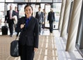 Happy businesswoman in suit holding briefcase