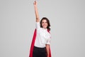 Happy businesswoman in superhero costume celebrating success