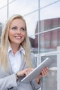 Happy businesswoman using digital tablet while looking away against office building Royalty Free Stock Photo