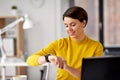 Happy businesswoman using smart watch at office Royalty Free Stock Photo