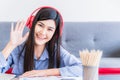 Happy businesswoman working from home. Asian female wear headphone use technology communication by laptop computer in living room Royalty Free Stock Photo