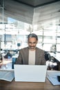 Happy busy middle aged business man using laptop computer in office. Vertical Royalty Free Stock Photo