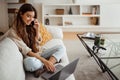 Happy busy young asian woman calling by smartphone, typing on computer Royalty Free Stock Photo