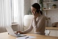 Happy busy young freelancer woman working in home kitchen Royalty Free Stock Photo