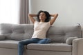 Happy black girl relaxing on comfortable couch at home Royalty Free Stock Photo