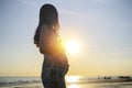 Silhouette of a pregnant woman walking on the beach at sunset Royalty Free Stock Photo