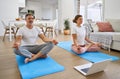 Happy middle aged couple learning online yoga class using laptop at home. Royalty Free Stock Photo