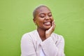 Happy, calm and young black woman by a green wall with trendy, classy and elegant jewelry and outfit. Fashion, smile and