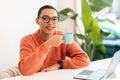 Happy calm young latin woman in glasses enjoy break and free time, drink cup of coffee Royalty Free Stock Photo